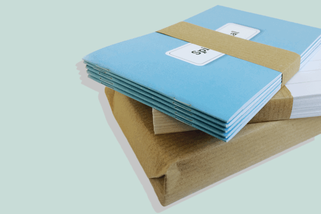 Gestapeltes Kairos Begleiter-Set von Rotmont mit mehreren blauen Coachingjournalen, seitlich gebündelt auf pastellfarbenem Hintergrund