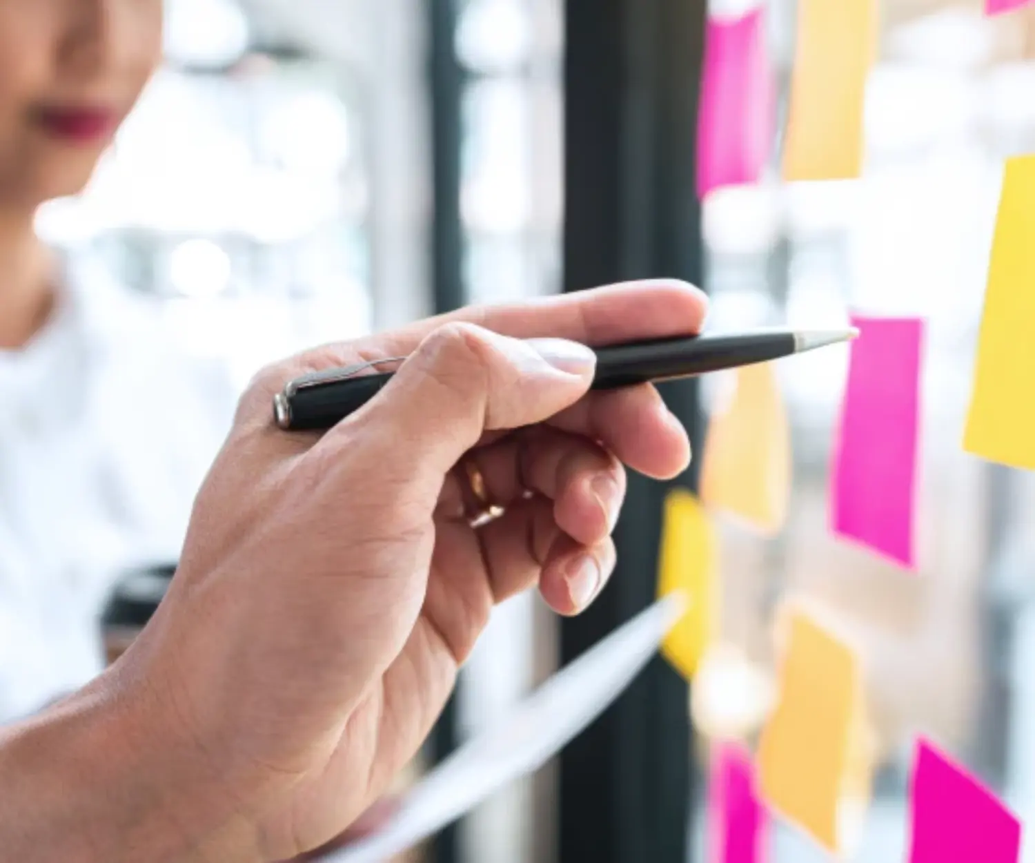 Hand zeigt auf Post-its zur Priorisierung